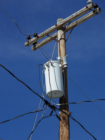 Typical US residential power distribution transformer mounted on a utility pole.
