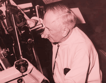 Astronomer Fritz Zwicky examining a photographic plate.