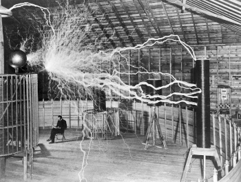 Nikola Tesla pictured with his high voltage spark generator